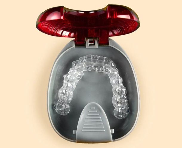 A clear retainer in a case with a red lid
