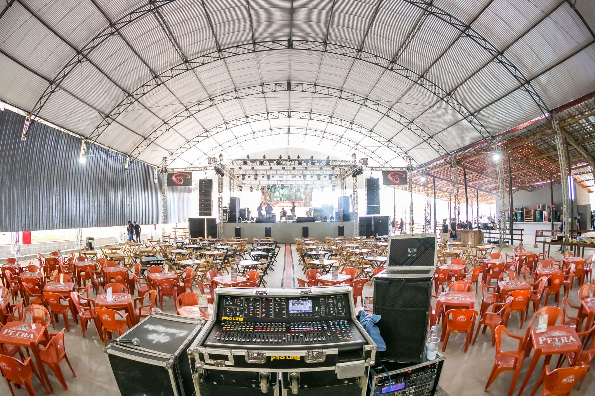 Uma grande sala cheia de mesas e cadeiras e um palco.