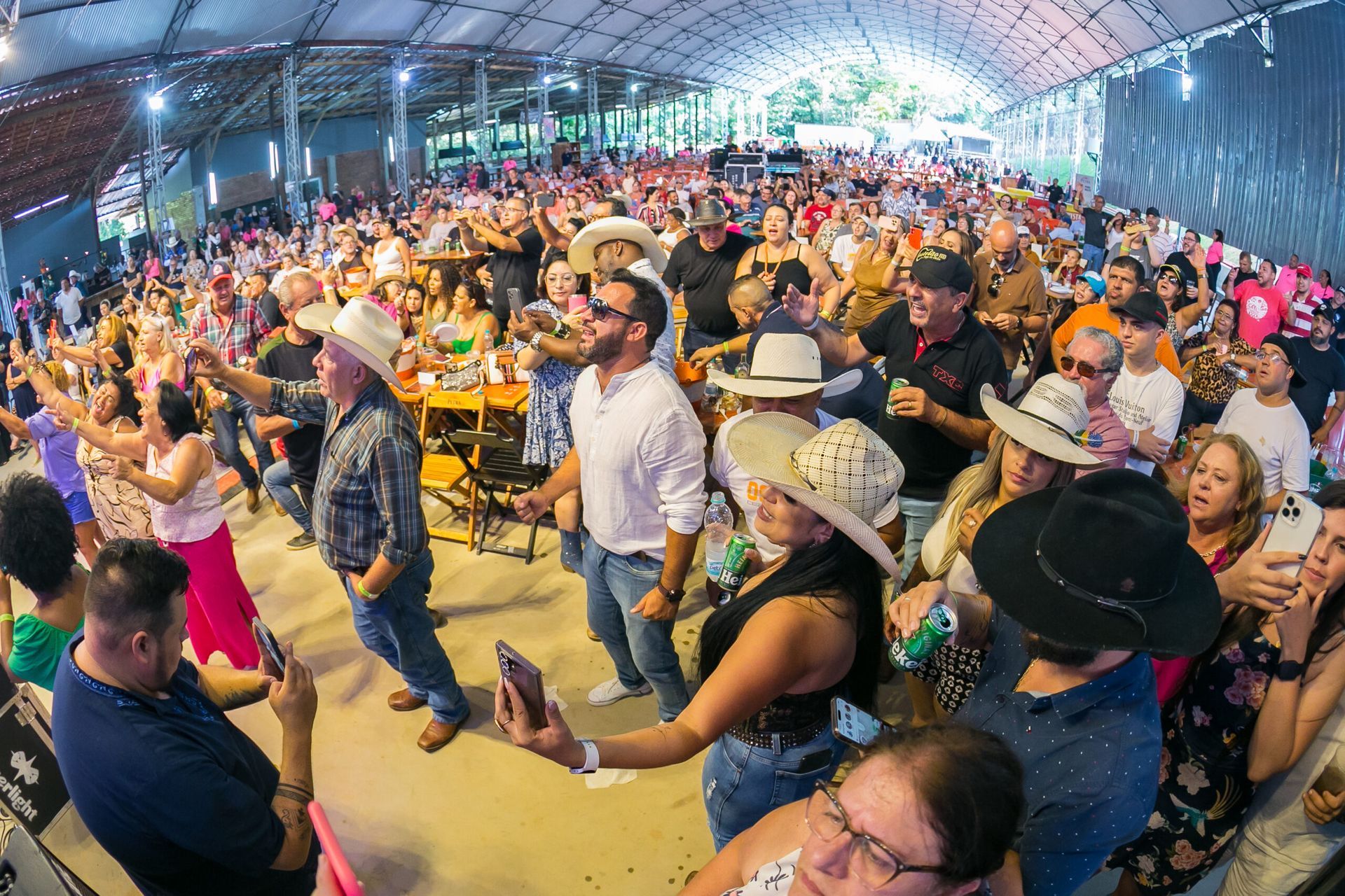 Um grande grupo de pessoas está dançando em uma sala grande.