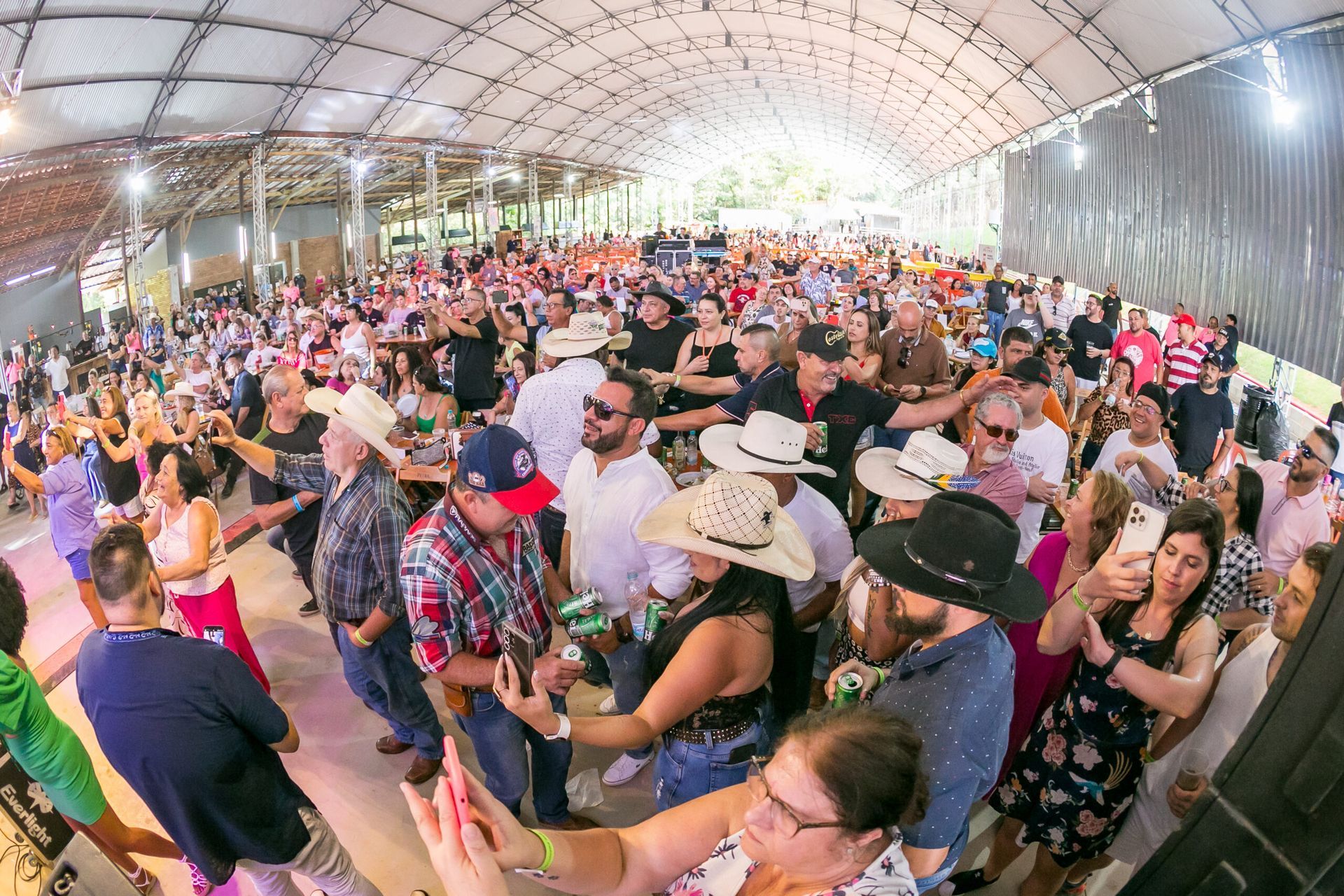 Um grande grupo de pessoas está dançando em uma sala grande.