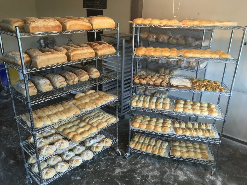 A bakery filled with lots of bread and pastries on shelves.