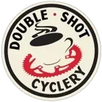 Double Shot Cyclery logo: coffee cup with bicycle chain outline, black and red on a cream circle.