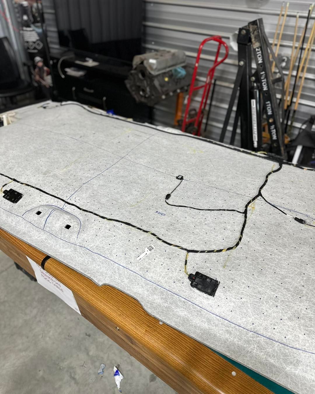Car ceiling headliner with wiring on a pool table, in a storage space.