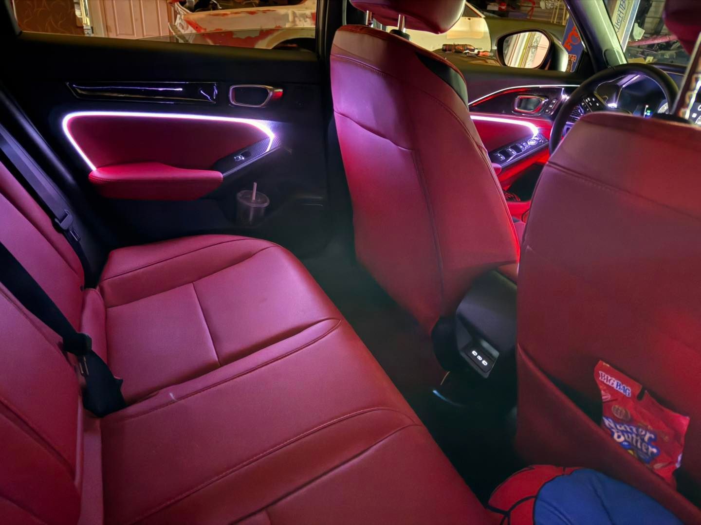 Red car interior with ambient white lighting.
