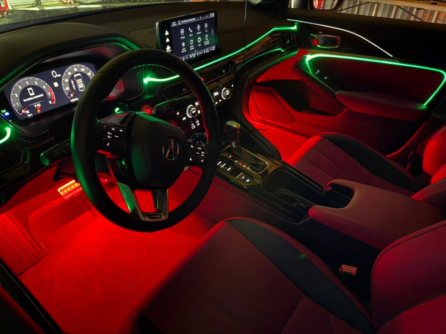 Red and green neon-lit car interior. Steering wheel, dashboard, seats, and console are visible.