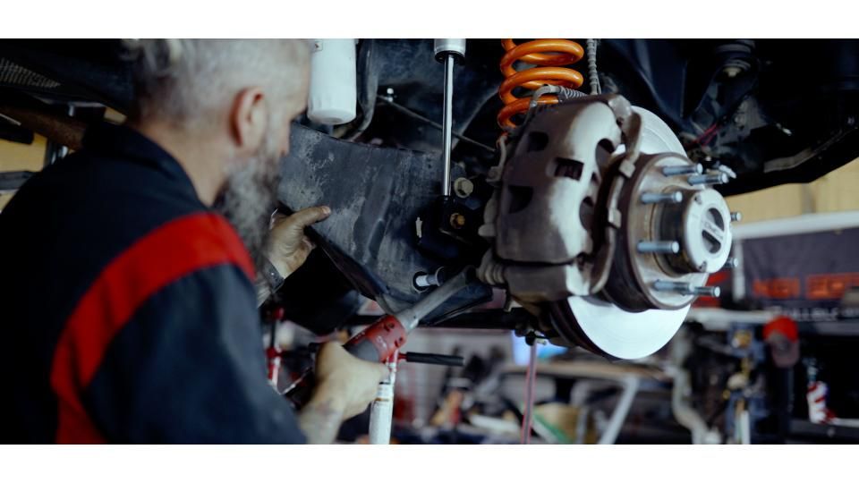 Fox shock absorber with a reservoir, in red lighting.