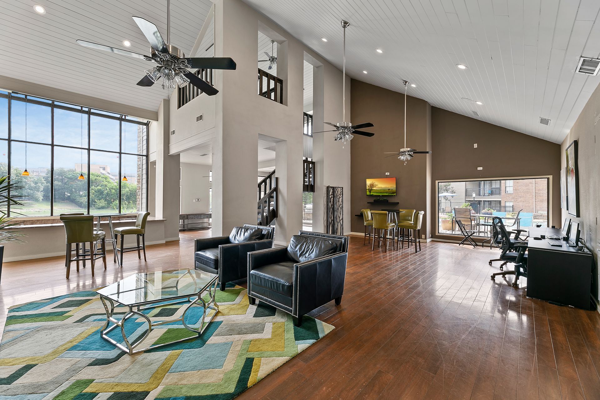 Photo of a community clubhouse, showing various places to sit and plenty of natural lighting