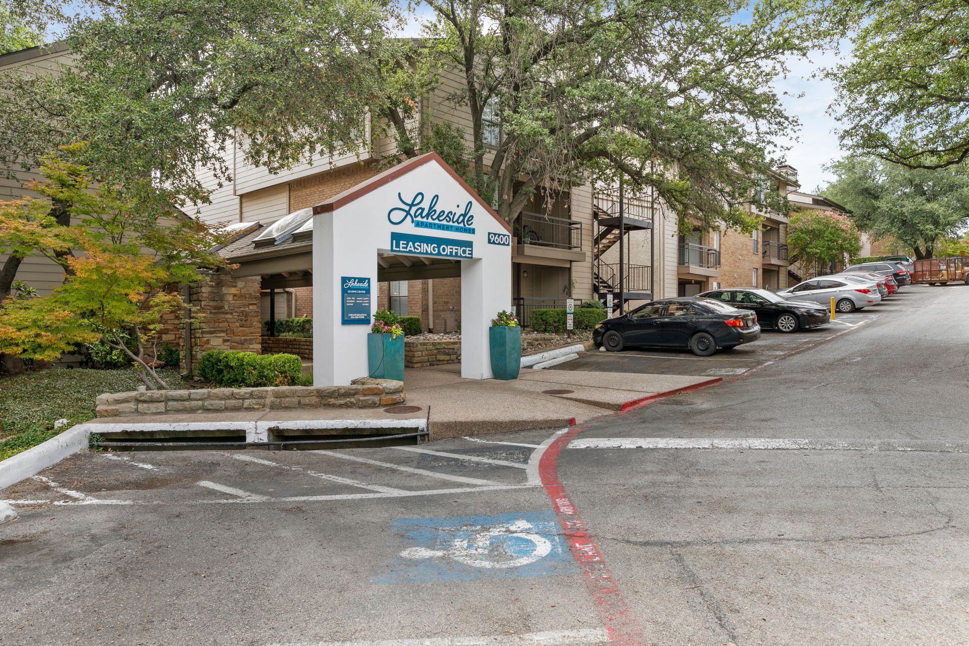 Photo of the entrance to the community, showing a driveway with parking