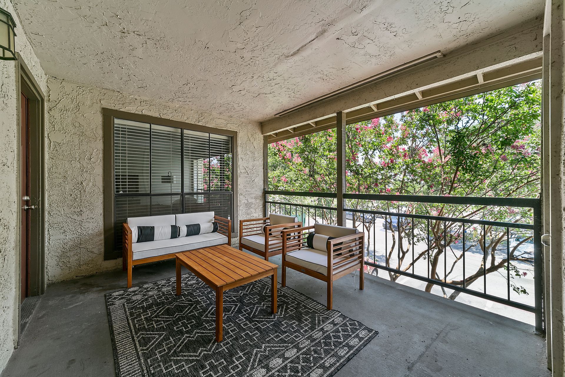 Photo of a large balcony showing a few places to sit, and still plenty of walking space