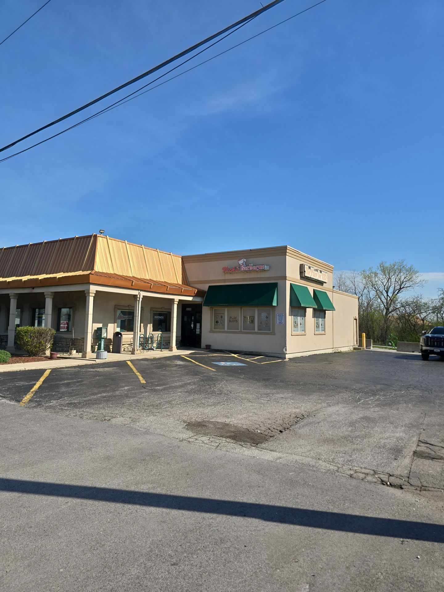 White commercial flat roof with black seams, vents, and surrounding buildings under a cloudy sky.