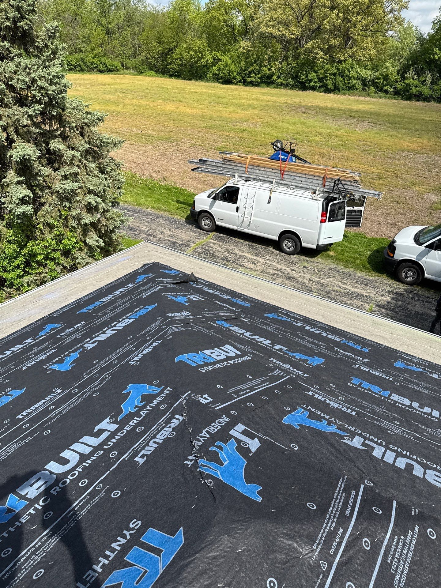 Close-up of a dark gray asphalt shingle roof with a visible ridge.