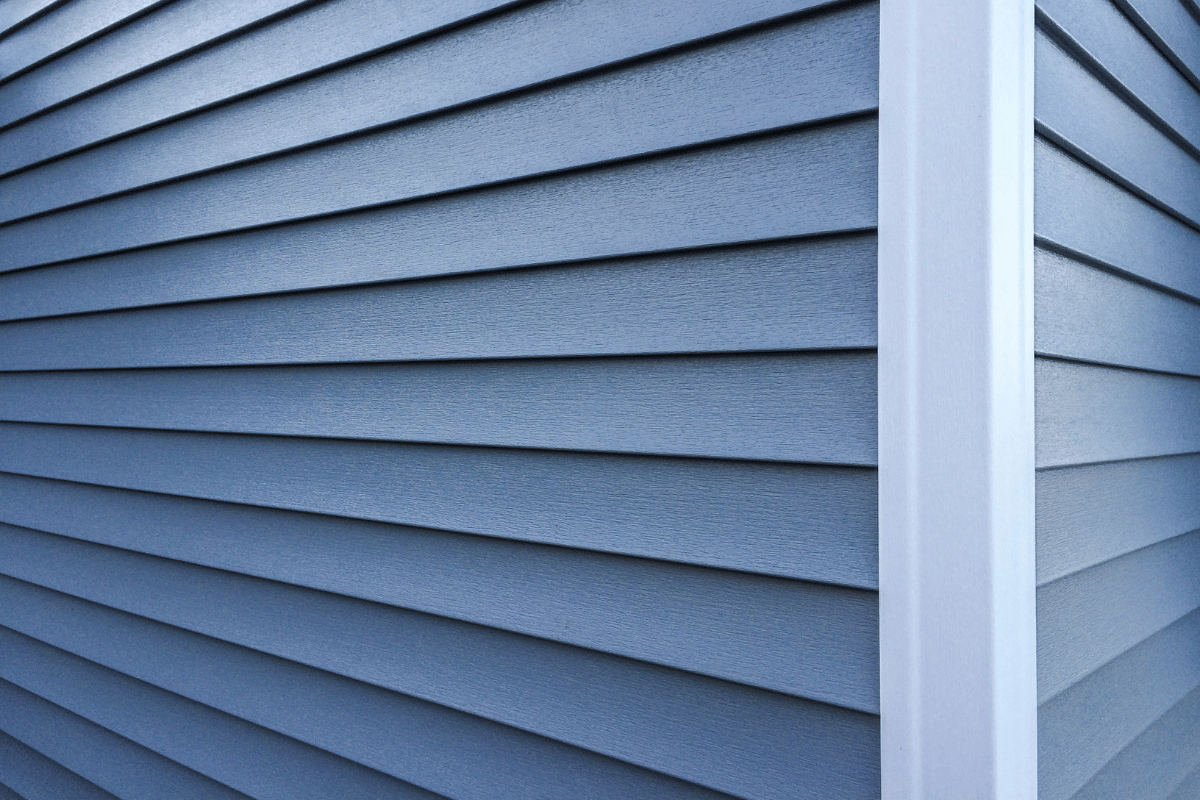 Blue siding on a building corner with a white trim column.