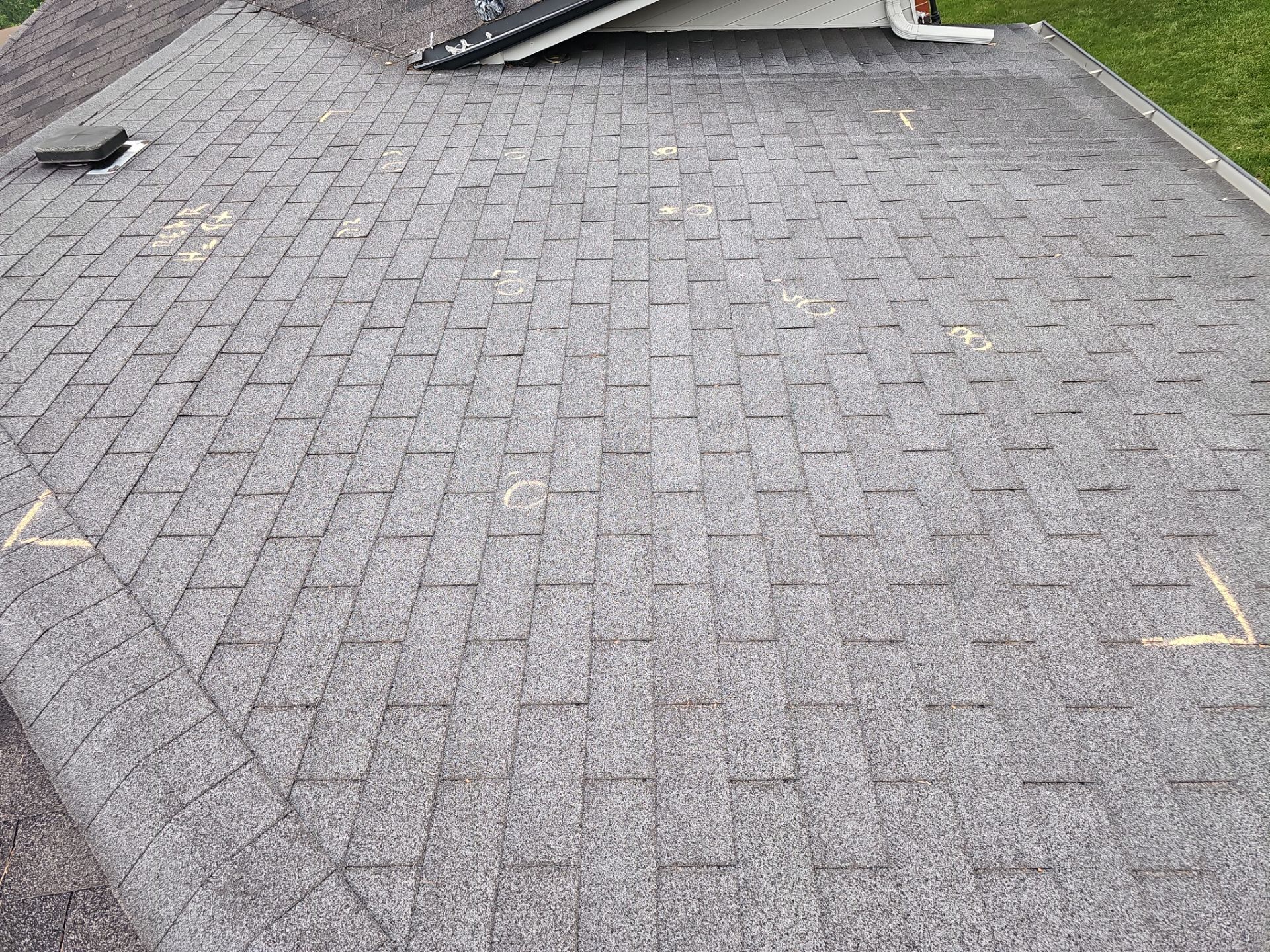 Aerial view of a blue metal roof under construction with three chimneys.