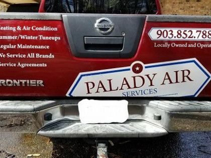 A red truck with a sticker on the back that says palady air services