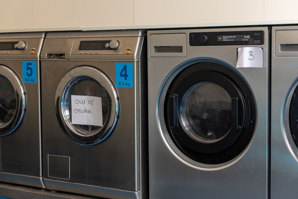 Row of silver washing machines, one with an