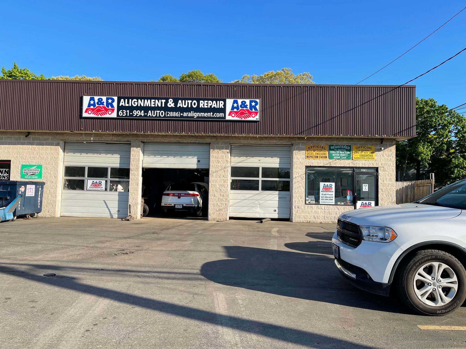 A&R Alignment & Auto Repair shop with a white SUV parked in front; a car is inside. | A & R Auto Repair