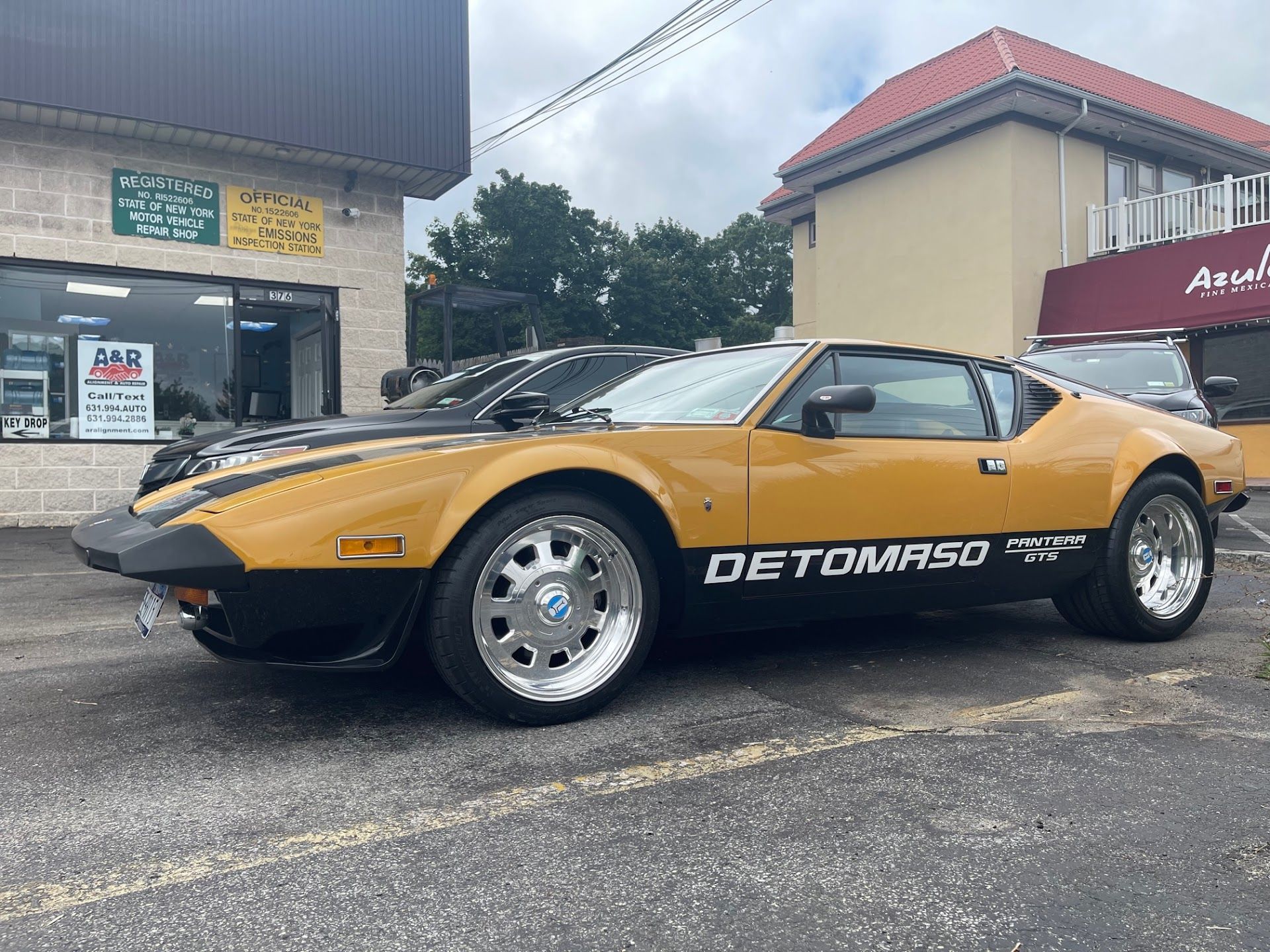 Yellow and black De Tomaso Pantera sports car parked outside a business. | A & R Auto Repair