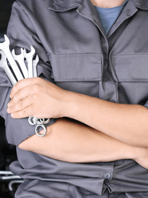 a mechanic holding wrenches