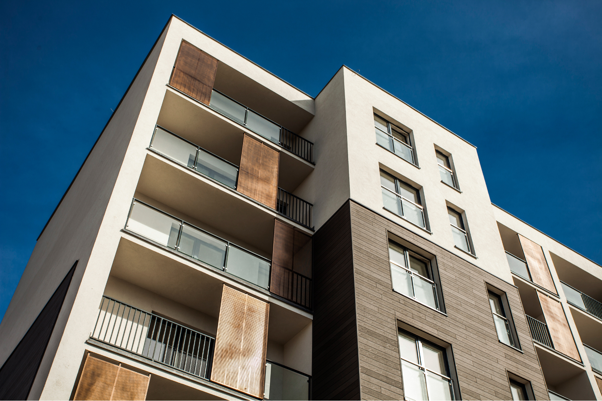 A large apartment building with a blue sky in the background