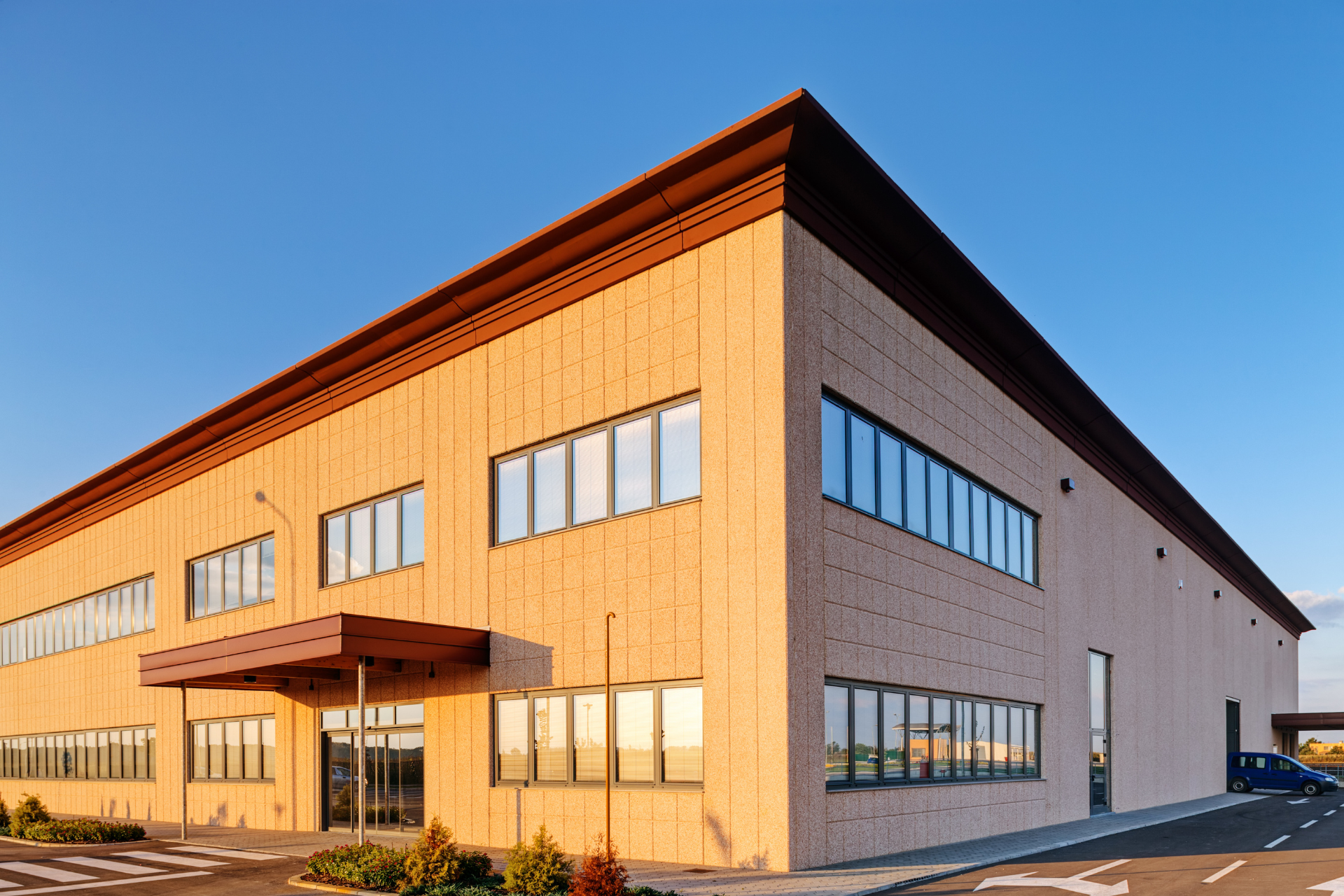 A large building with a lot of windows and a blue sky in the background