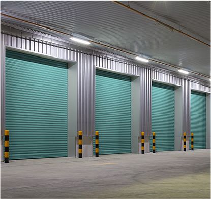 a row of green garage doors in a warehouse .