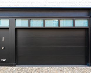 a black garage door with a lot of windows on it .
