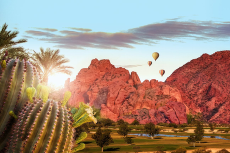 Desert landscape with hot air ballooons floating above mountains