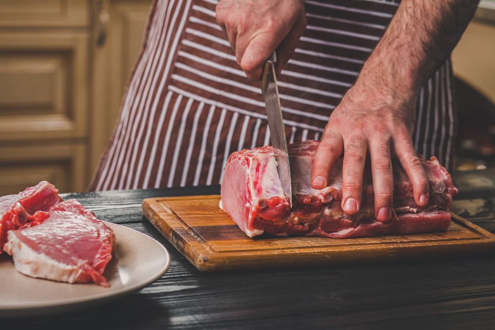 Raw Beef Steaks being chopped up by a person  — LZH Butchers in Bungalow, QLD
