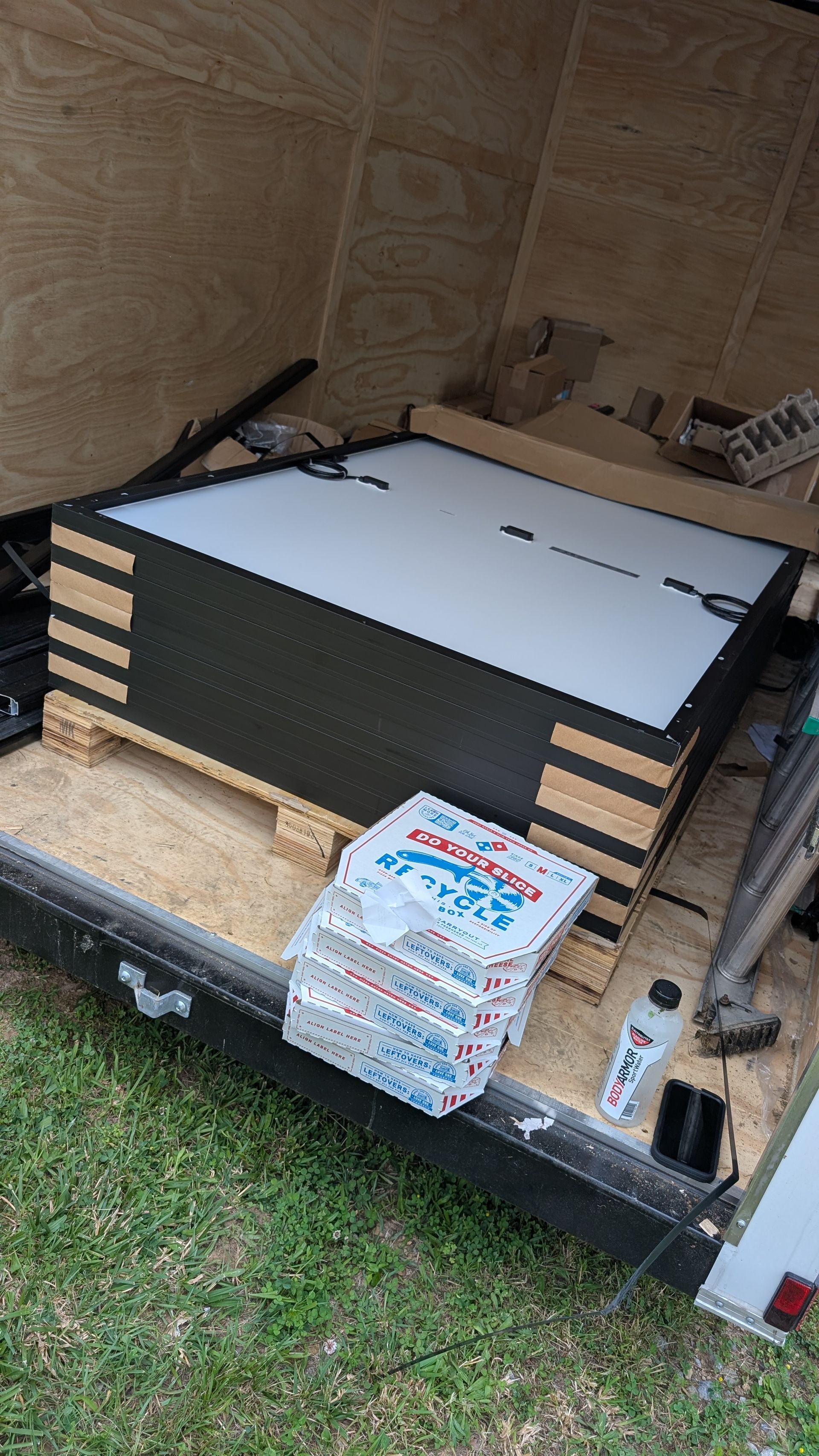 A stack of pizza boxes sitting on top of a trailer.