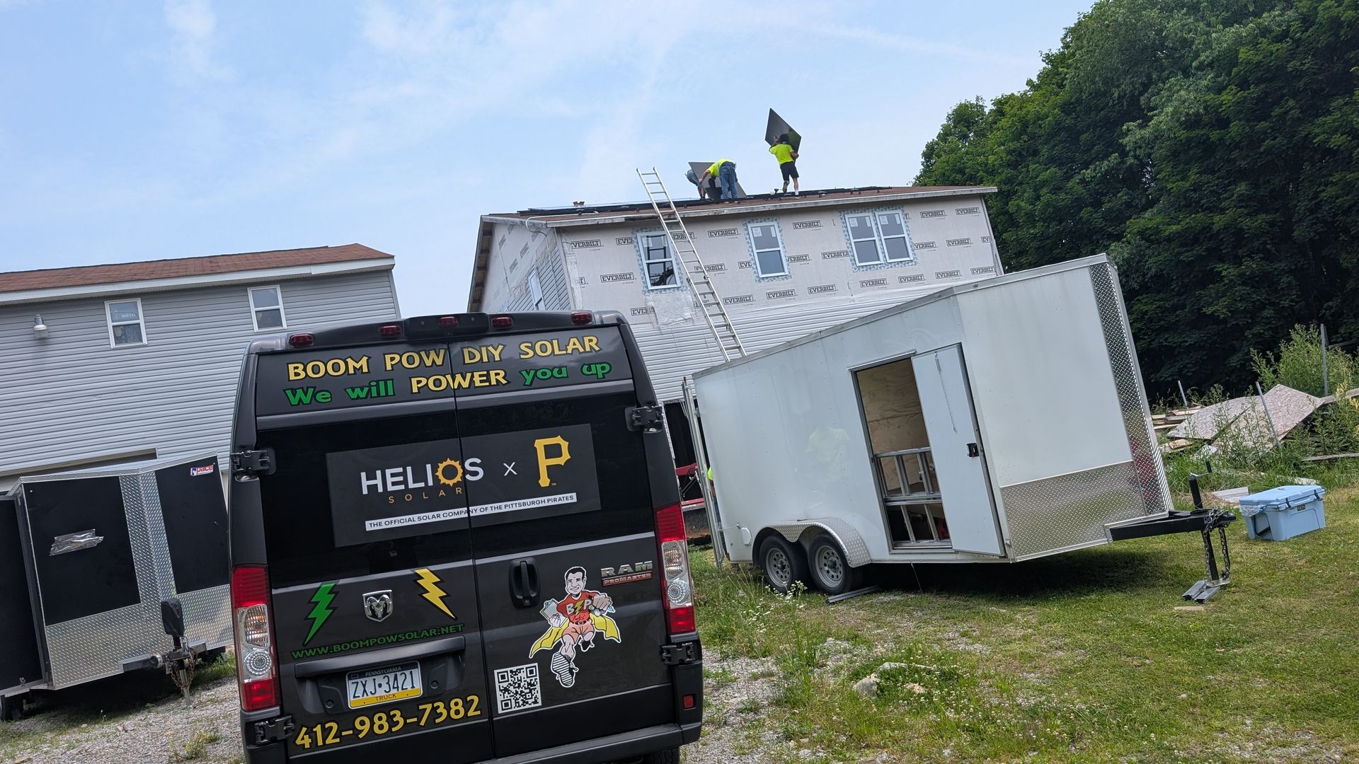 A van is parked in front of a building and trailers.