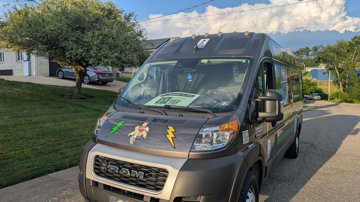 A van is parked in a driveway in front of a house.