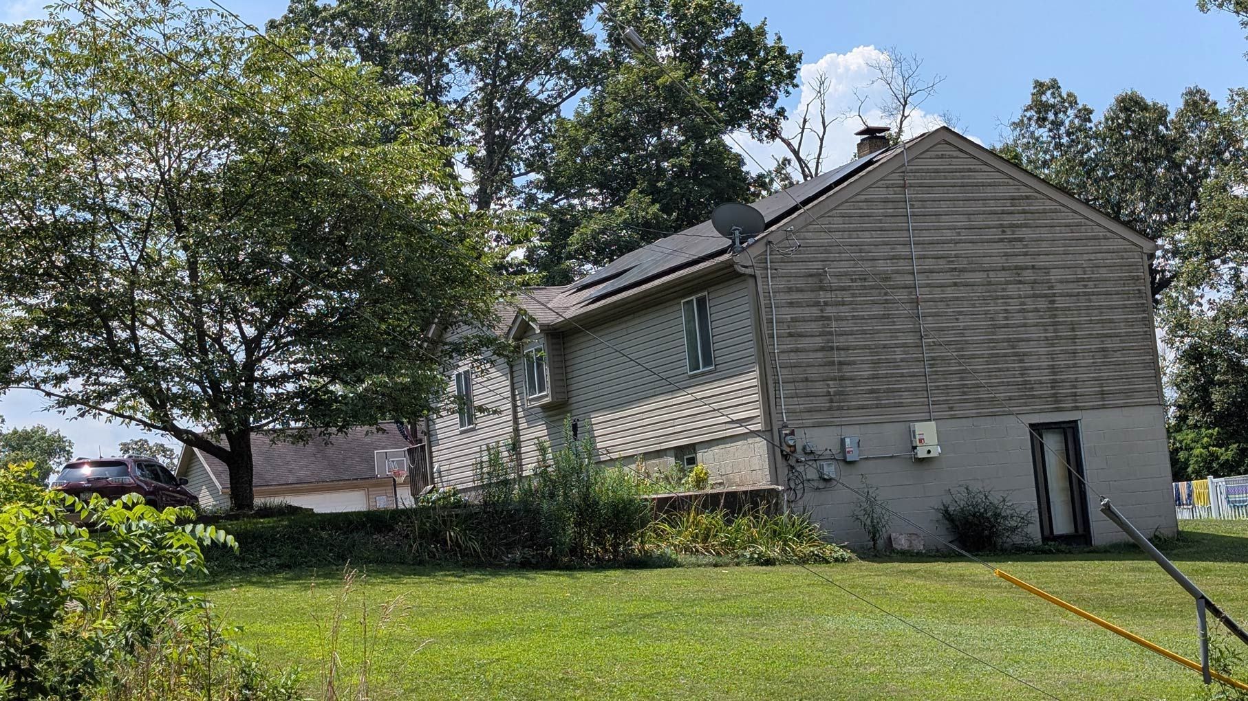 A house is sitting in the middle of a lush green field.