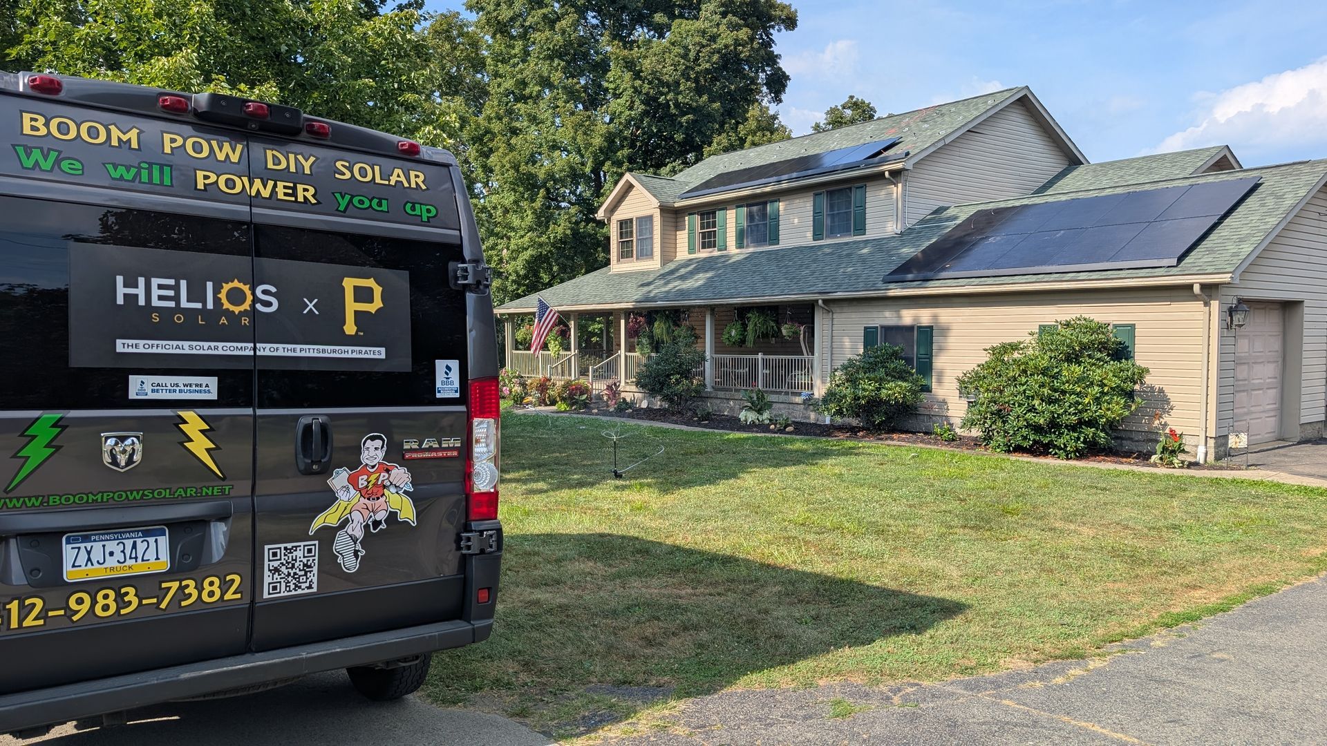 A van parked in front of a house with solar panels on the roof.
