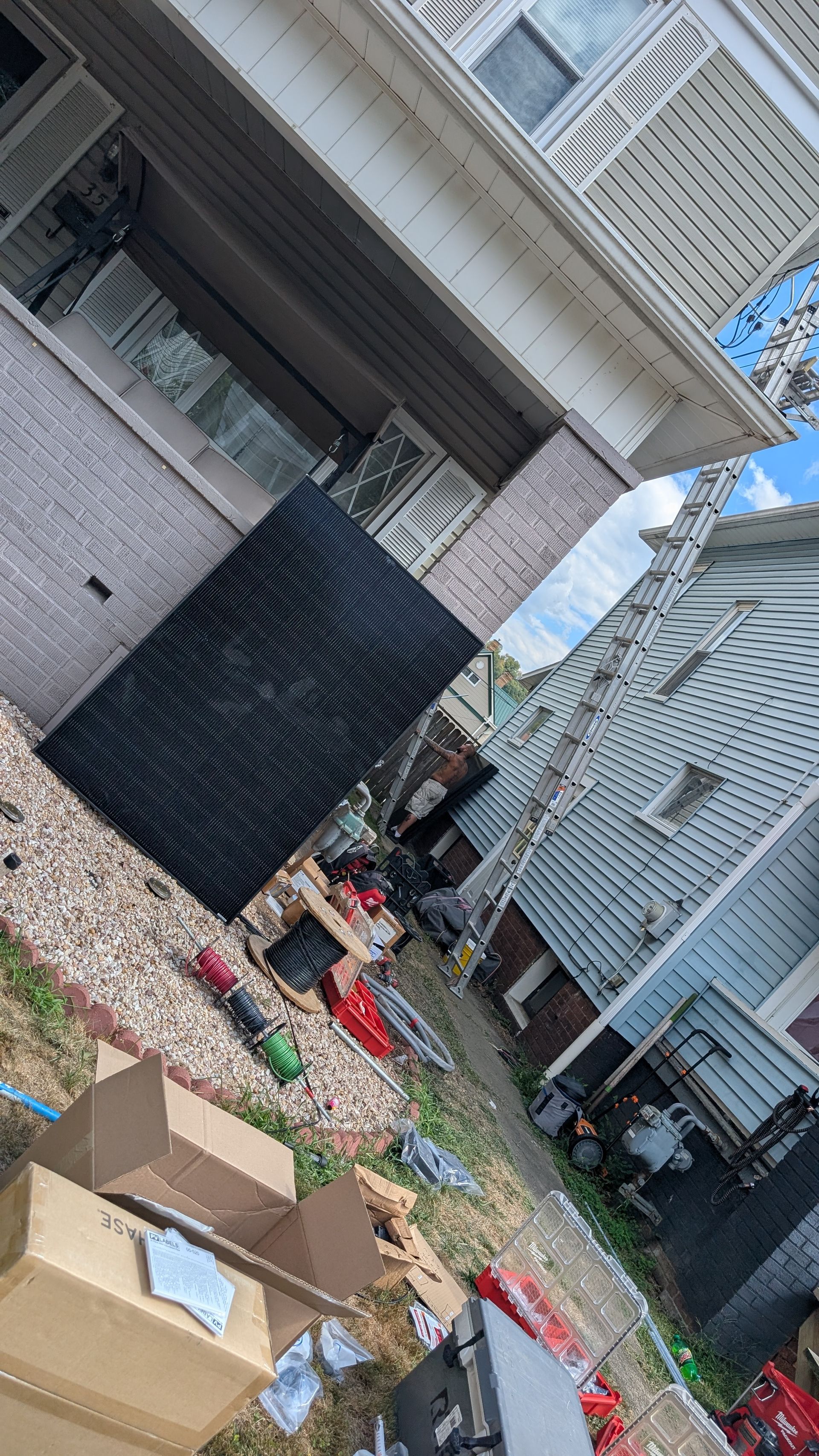 Exterior view of a messy yard with debris and a damaged building.