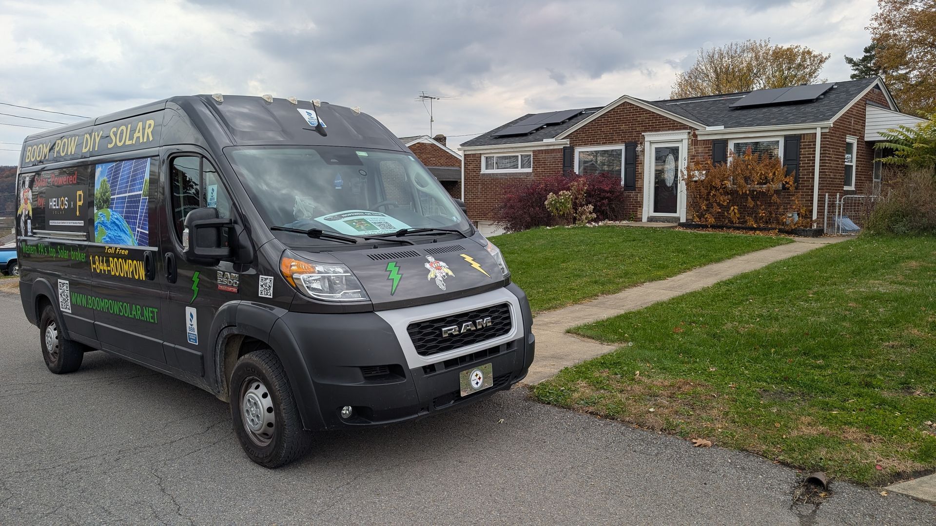 Black van with decals parked in front of a house