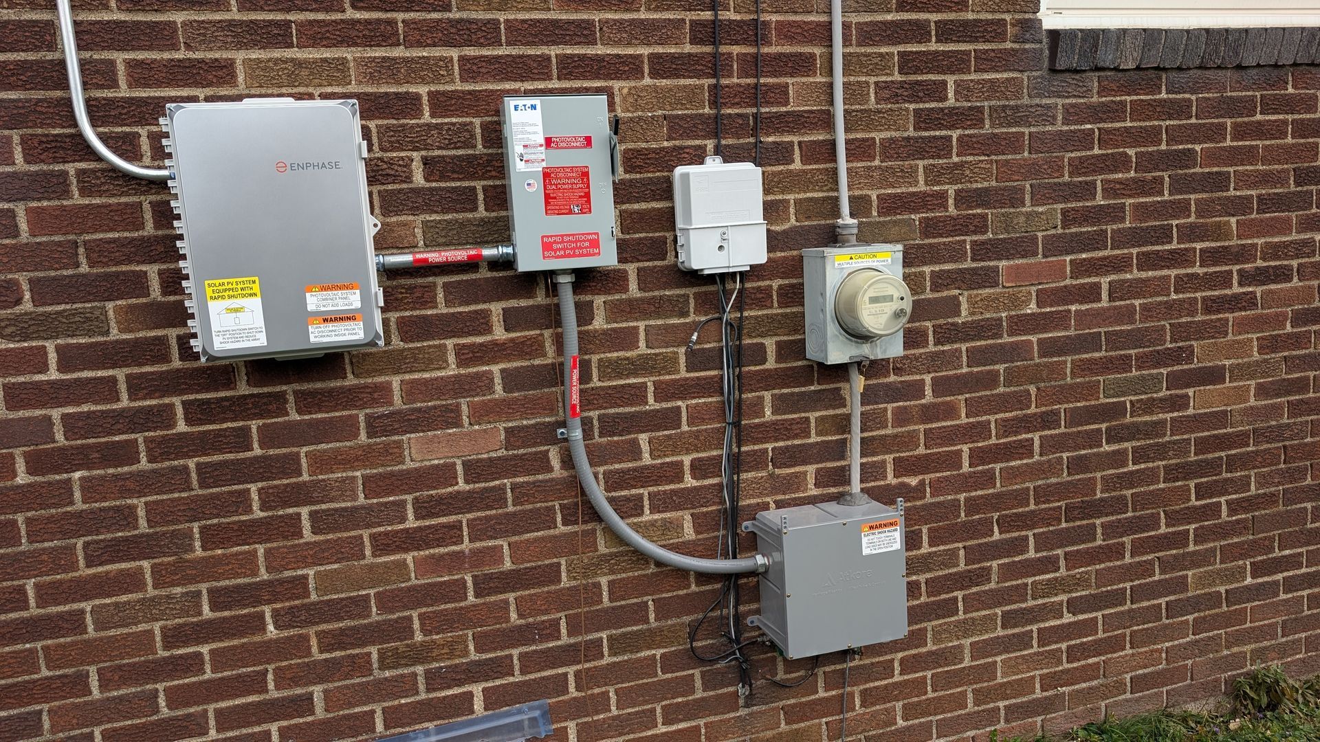 Electrical boxes and meter mounted on a brick wall