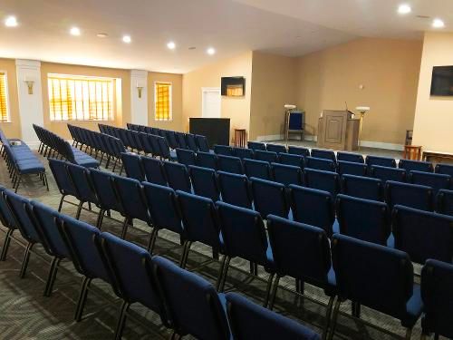 A large auditorium filled with blue chairs and a podium.
