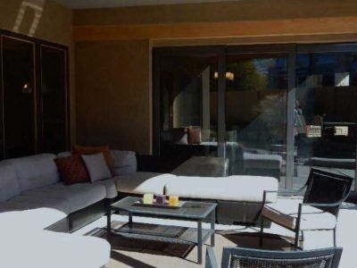 Outdoor patio with sectional sofa, coffee table, and sliding glass doors.