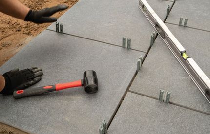 A man laying paving slabs on a patio design in Croydon