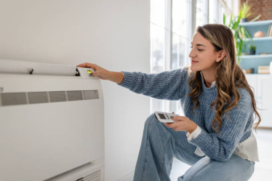 A woman adjusting the temperature on her winter heating system with a vent