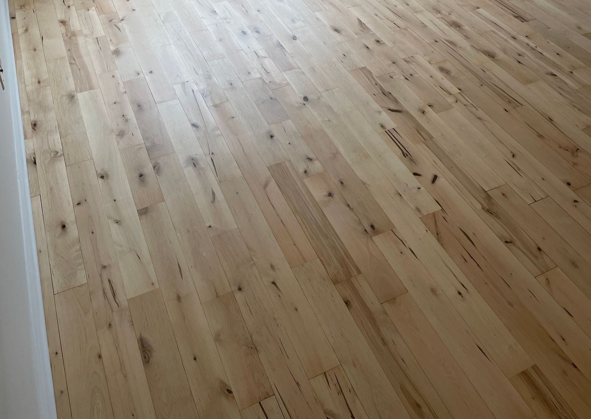 Plancher en bois, marron clair, avec veinage visible.