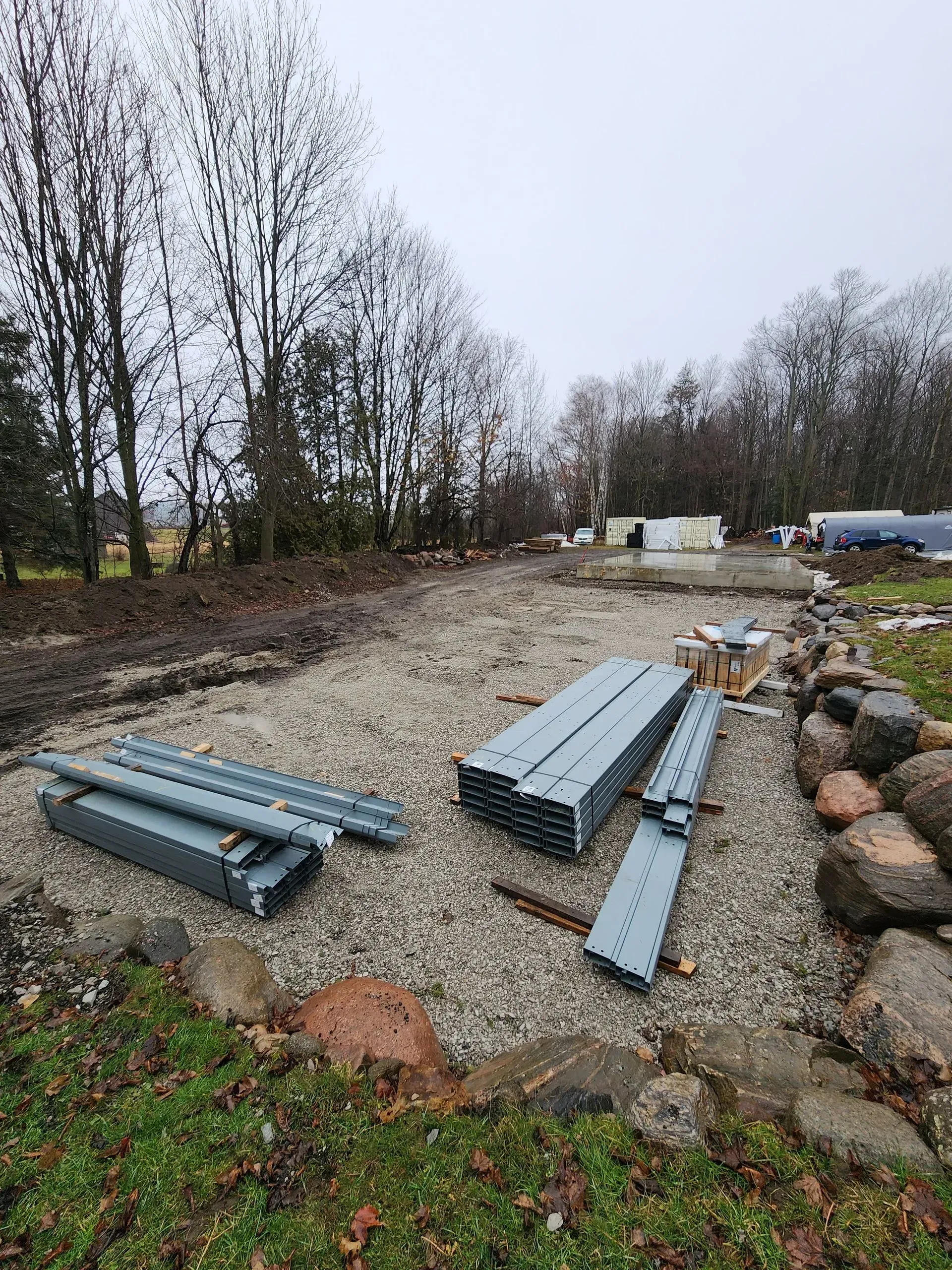 A pile of metal pieces sitting on top of a gravel road.
