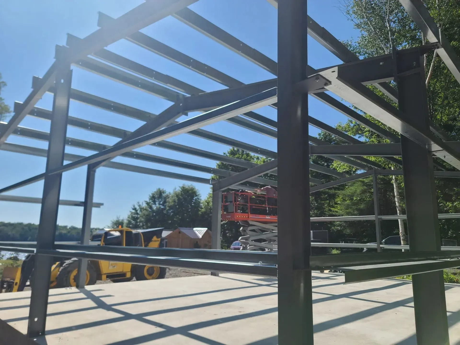 A large metal structure is being built on a sunny day.