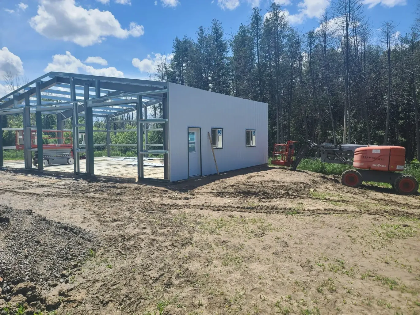 A tractor is parked in front of a building under construction.