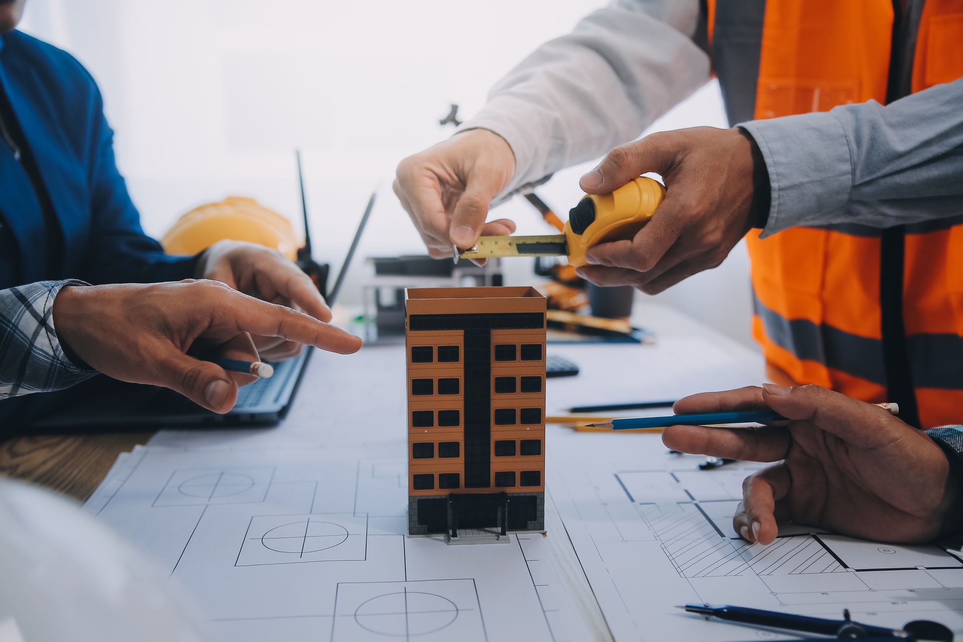 A group of construction workers are working on a model building.