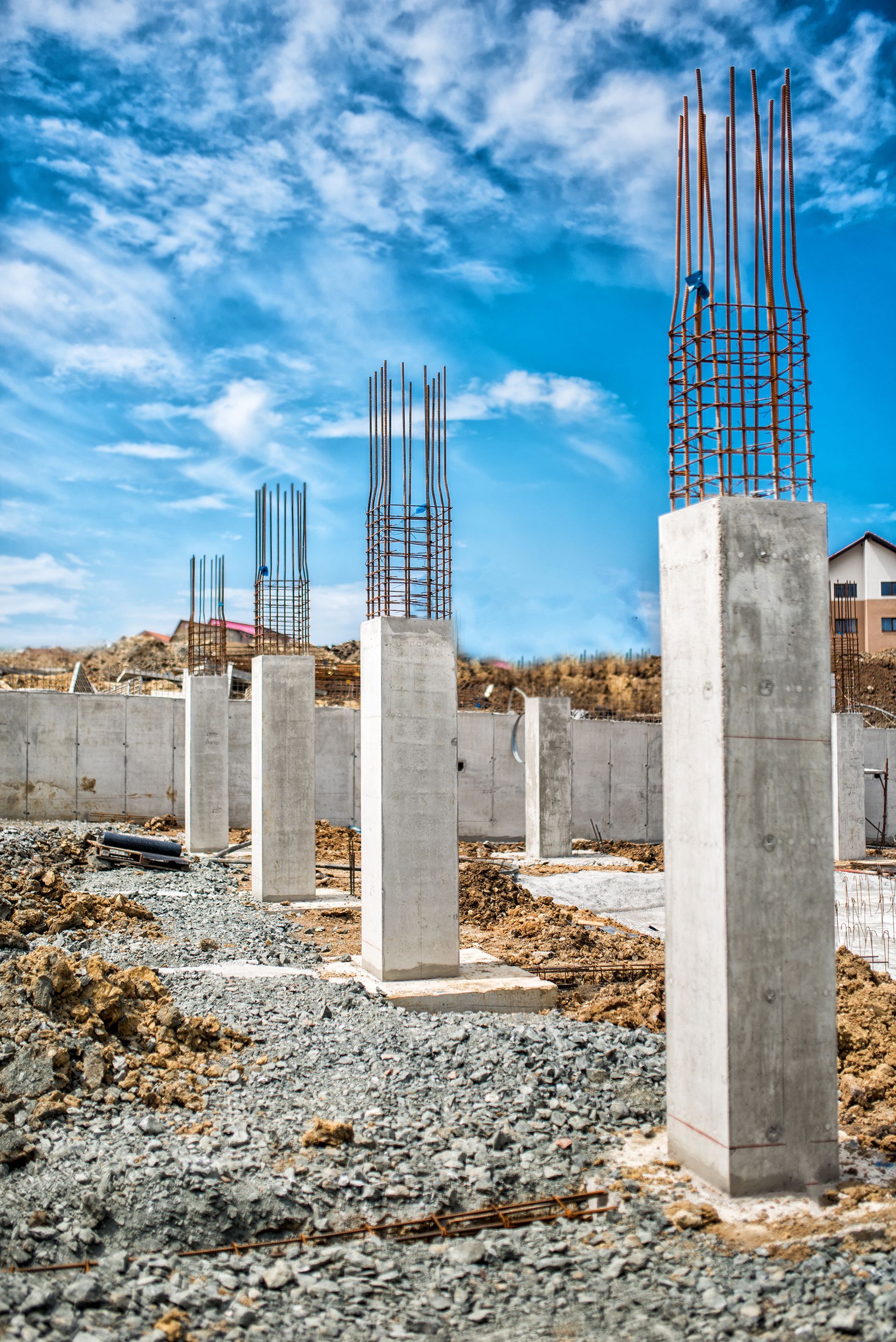 A row of concrete pillars are being built on a construction site.