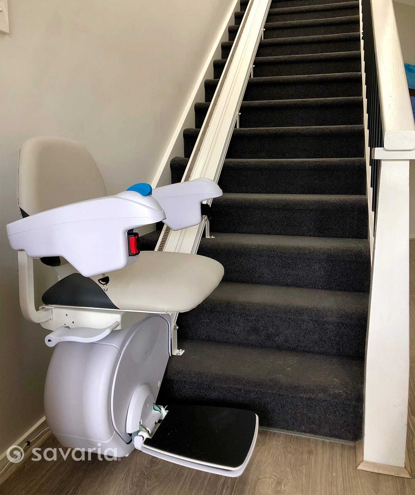 A White Stair Lift Is Sitting on Top of A Set of Stairs — Master Lifts Cairns in Cairns, QLD