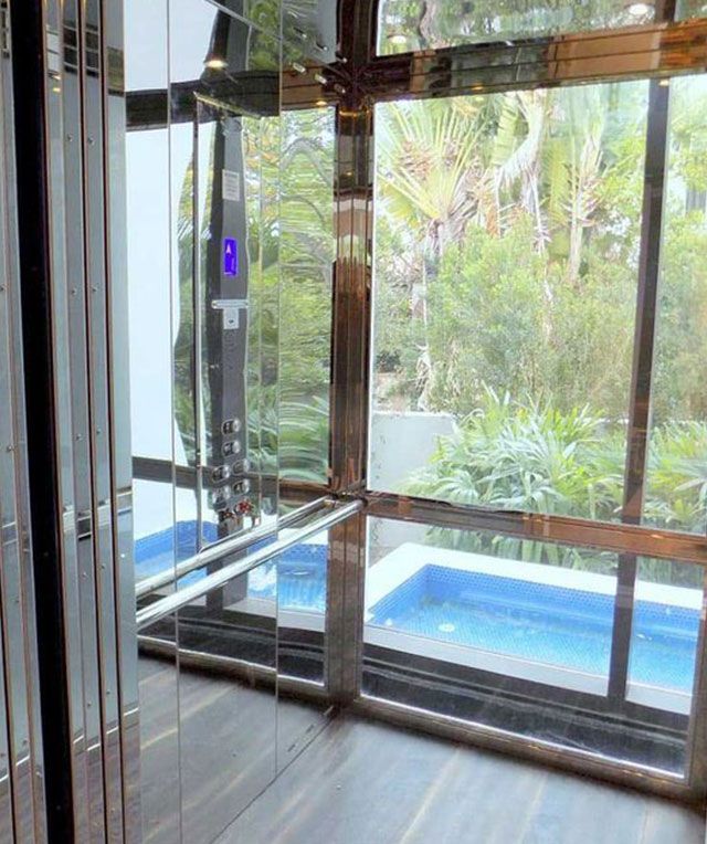 An Elevator with A Large Window and A Pool in The Background — Master Lifts Cairns in Cairns, QLD