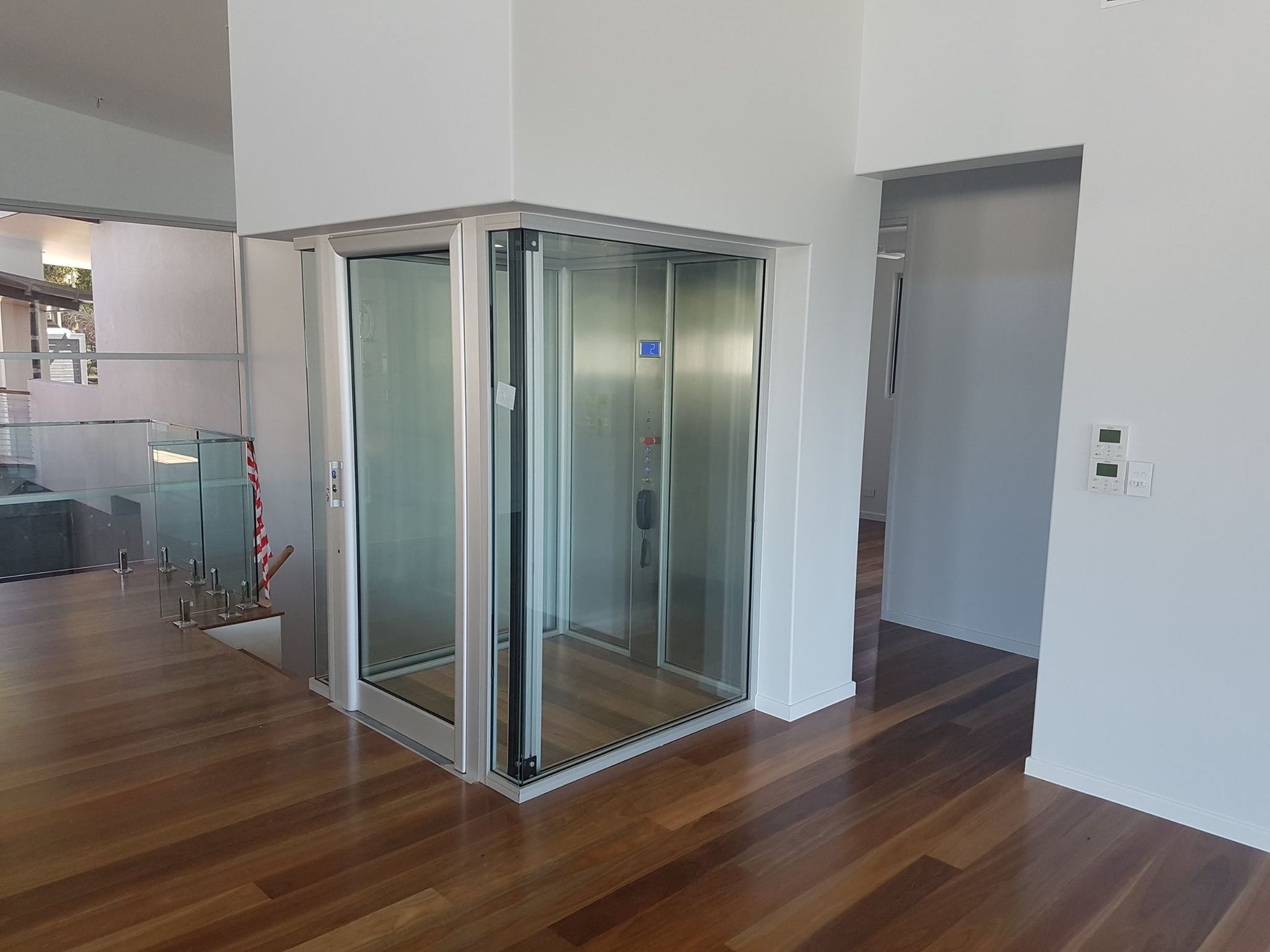 An Elevator Is in The Corner of A Room with Hardwood Floors — Master Lifts Cairns in Cairns, QLD