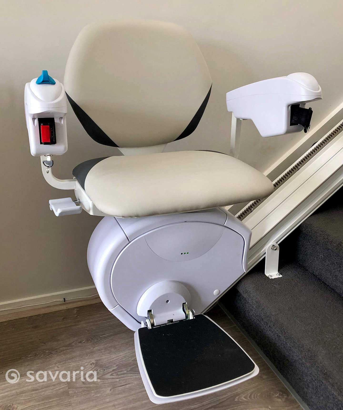 A White Stair Lift Is Sitting on A Set of Stairs — Master Lifts Cairns in Cairns, QLD